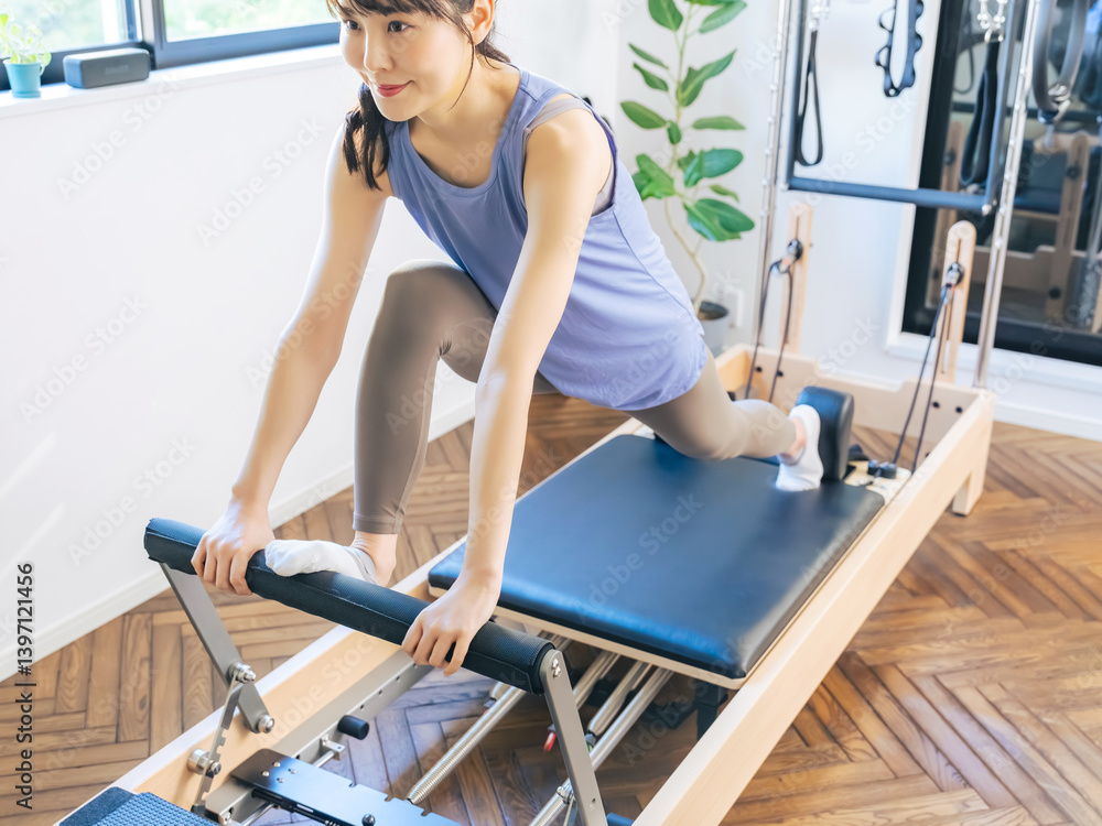 マシンピラティスのトレーニングをする女性 マシンピラティスのトレーニングをする女性