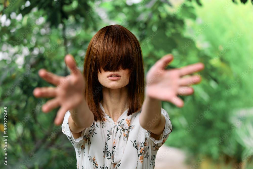 Mysterious woman surrounded by trees with outstretched hands in front of her face Mysterious woman surrounded by trees with outstretched hands in front of her face