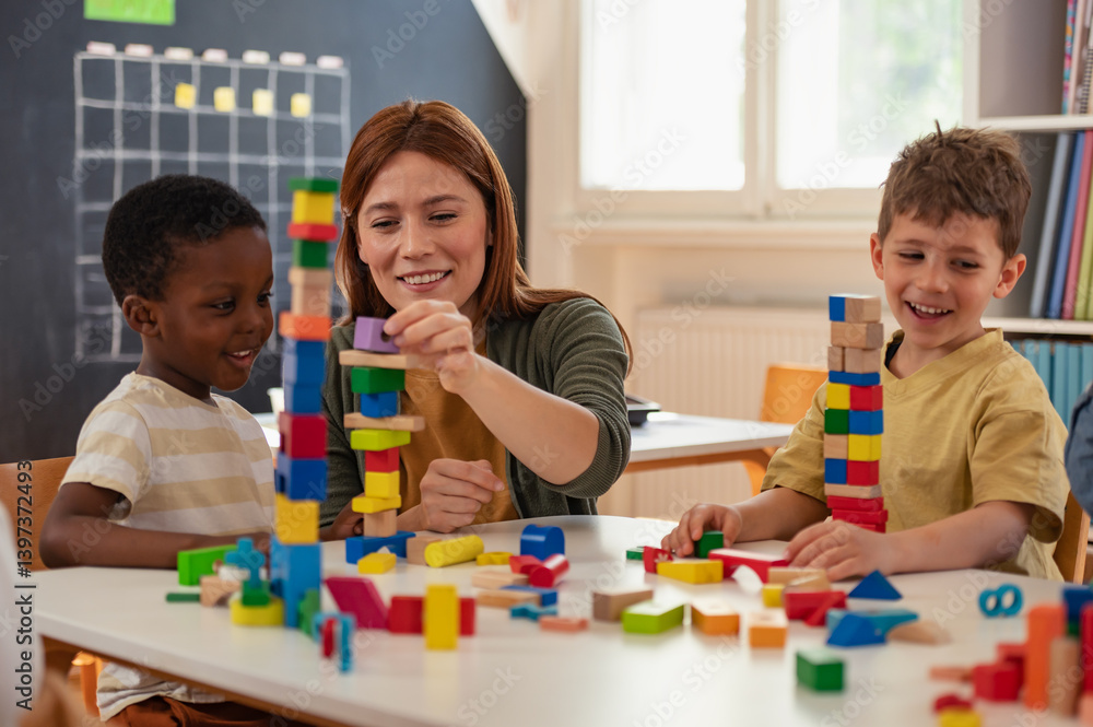 Fototapeta premium Multicultural group of preschool children playing with colorful building blocks in a bright classroom, developing creativity, motor skills, and teamwork through imaginative play.