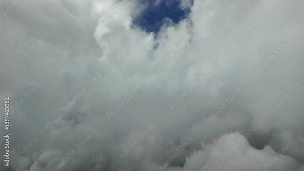 An immersive aerial view through the pilot’s eyes in a reat time flight through threatening storm cumulus clouds, under an intense blue sky. An immersive aerial view through the pilot’s eyes in a reat time flight through threatening storm cumulus clouds, under an intense blue sky.