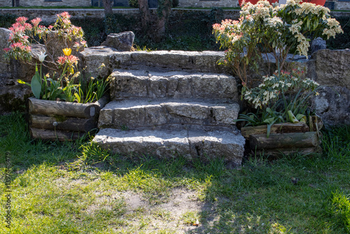 Four Granite steps up to river defence in Lostwithiel with flowers