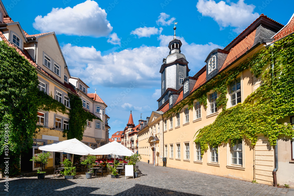 Baroque alley with ivy-covered facades and outdoor cafe near Gotha’s historic market square