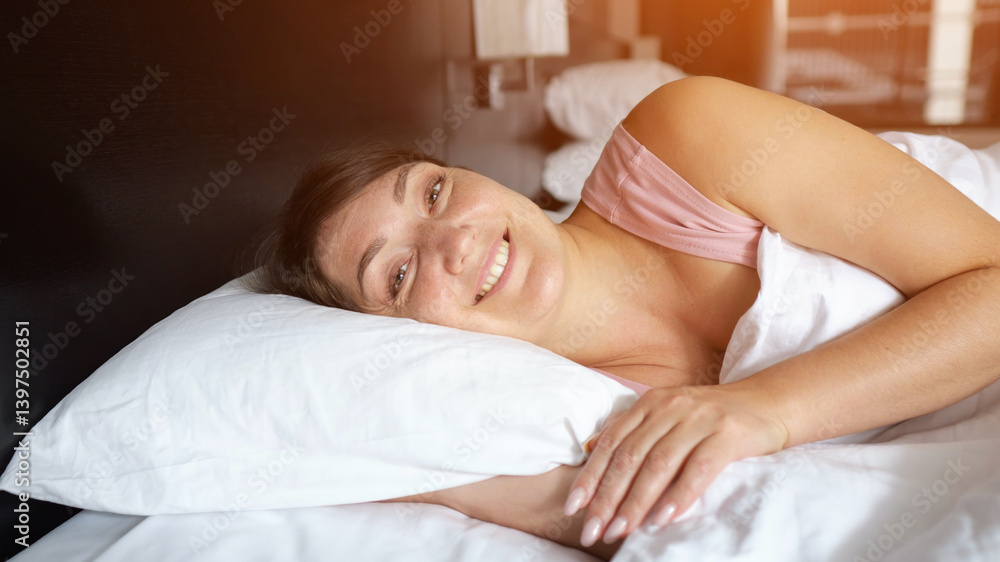 Woman sleeping peacefully and waking up smiling in hotel room Woman sleeping peacefully and waking up smiling in hotel room