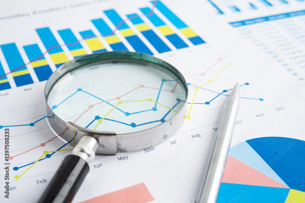 Magnifying glass on spreadsheet and graph paper. Financial data economy, Business. Magnifying glass on spreadsheet and graph paper. Financial data economy, Business.