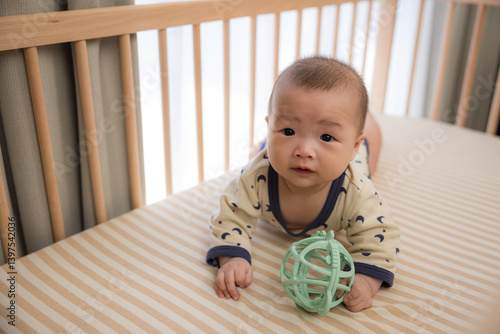 Obraz na płótnie Baby turning and crawling on bed with play ball w salonie
