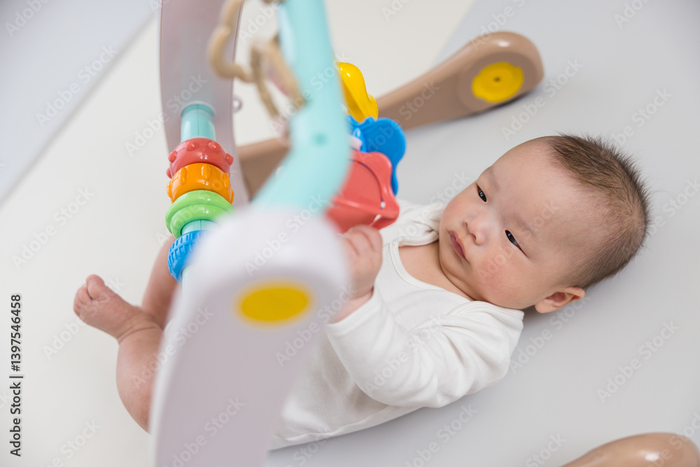 Cute baby playing with colorful hanging toy