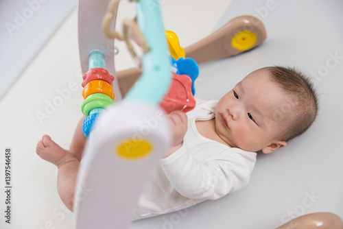 Obraz na płótnie Cute baby playing with colorful hanging toy w salonie
