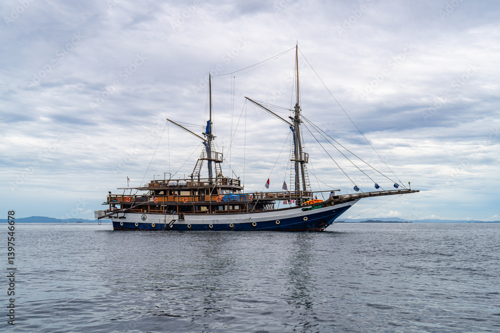 Elegant traditional boat floating on still ocean water in exotic Indonesian seascape Elegant traditional boat floating on still ocean water in exotic Indonesian seascape