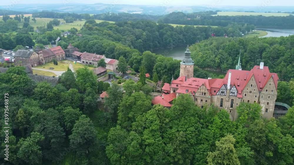 Czocha Castle nestled in dense woodland with red rooftops and medieval architecture. Czocha, Poland Czocha Castle nestled in dense woodland with red rooftops and medieval architecture. Czocha, Poland