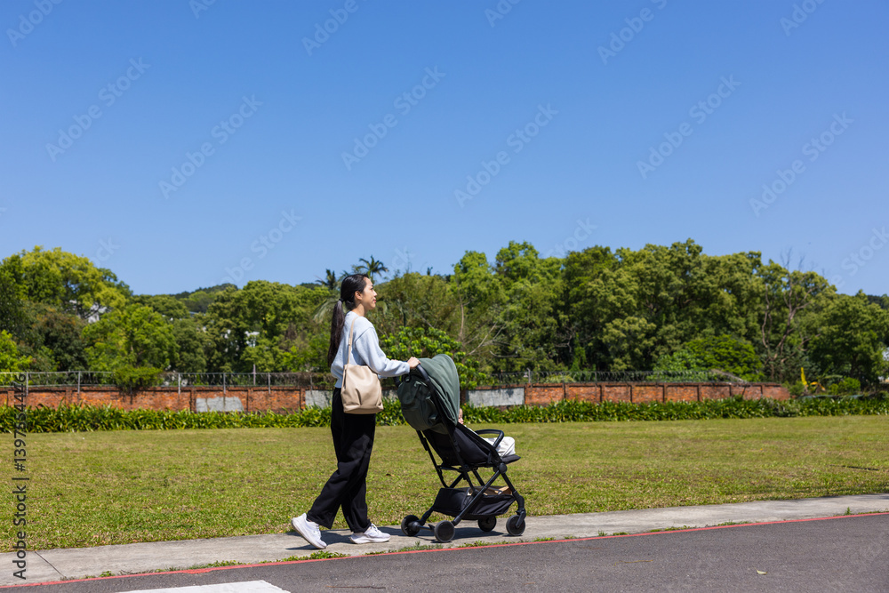 Mother Pushing Stroller in the park