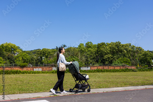 Obraz na płótnie Mother Pushing Stroller in the park w salonie