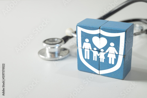 Family health insurance icon on wooden blocks with stethoscope on white background. Concept for medical protection, healthcare policy, family wellness, and affordable health coverage plan.