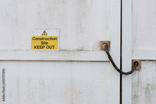 Construction Site Keep Out warning sign with symbol in yellow and black on white wooden gate panel
