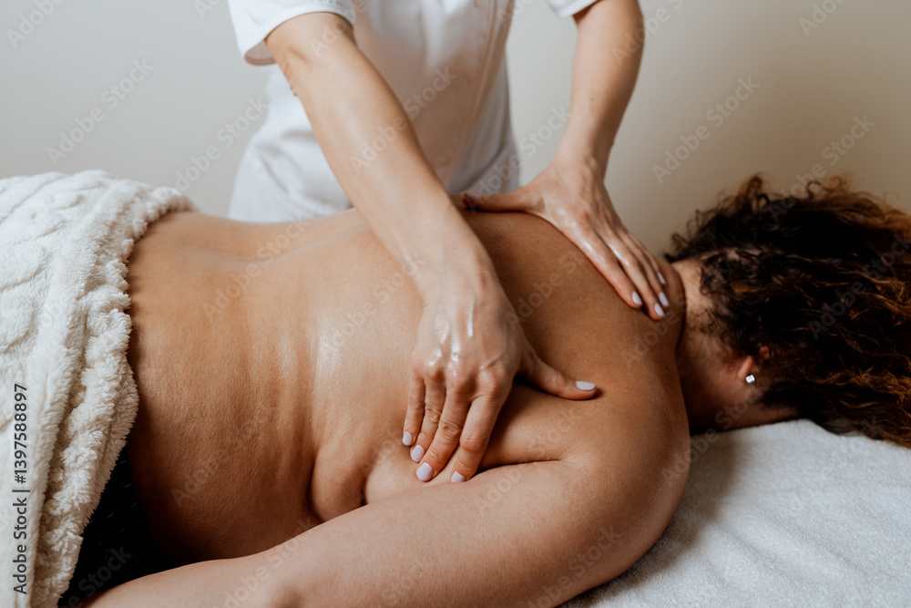 Fototapeta premium Obese middle-aged woman receives a special body massage intended for weight reduction and correction of bad posture. Modern weight loss physical therapy and beauty spa concept.