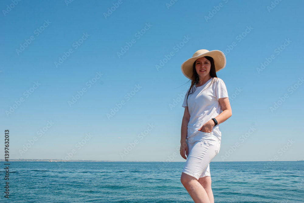 Woman enjoying a sunny day at the beach in casual summer outfit. Happy summer days, travel and vacation concept