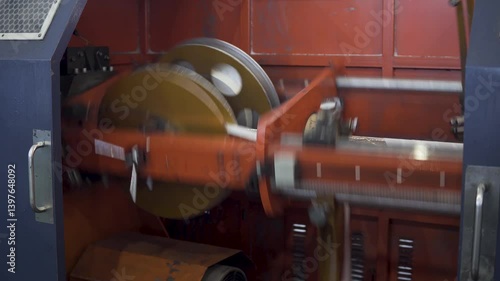 Detailed look at machinery operating within a factory. The equipment works efficiently, demonstrating production methods and mechanical interactions.