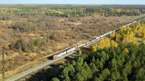 Freight train ride through vibrant autumn landscape in remote wilderness. Lush green trees contrast beautifully with golden foliage