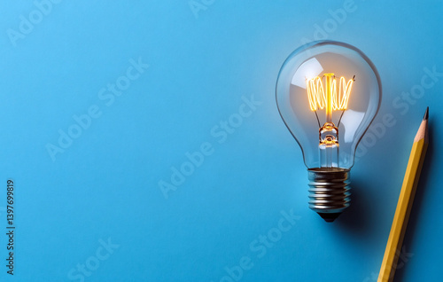 Bright Idea: A lit light bulb and a pencil suggest inspiration and creative thinking on a blue background.