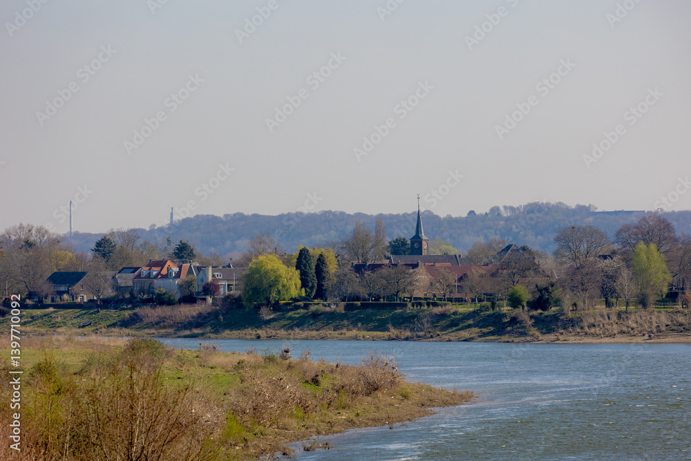 Spring landscape with green grass meadow, Countryside along the Meuse (Maas rivier) border between Belgium and Netherlands, Architecture traditional houses and church in small town, Itteren, Limburg. Spring landscape with green grass meadow, Countryside along the Meuse (Maas rivier) border between Belgium and Netherlands, Architecture traditional houses and church in small town, Itteren, Limburg.