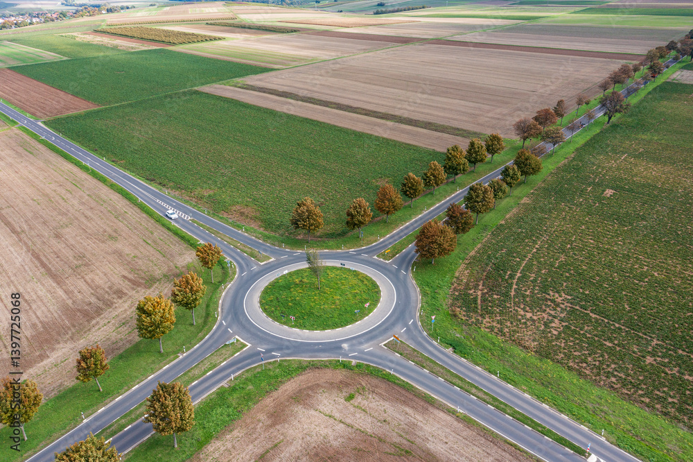 A bird's-eye view of a roundabout in Rheinhessen surrounded by fields and meadows A bird's-eye view of a roundabout in Rheinhessen surrounded by fields and meadows