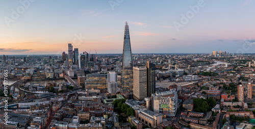 Aerial view of the modern shard skyscraper amidst a vibrant cityscape at dusk with the River Thames, Southwark, England, United Kingdom.