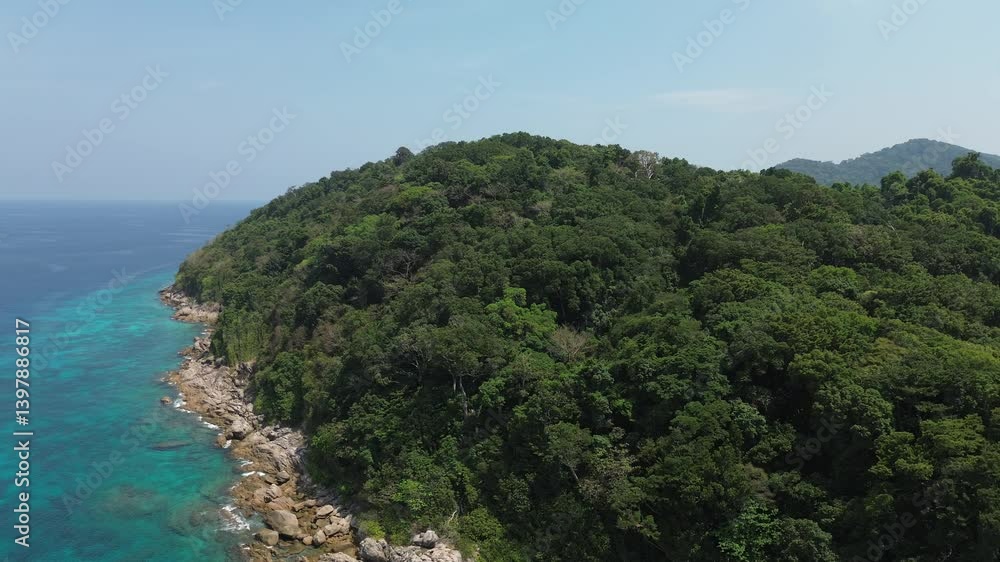 Drone aerial shot of Similan Islands in the Andaman Sea in Thailand with liveaboard scuba diving boats in the bay surrounded by beautiful tropical blue water and rocky island with jungle and waves Drone aerial shot of Similan Islands in the Andaman Sea in Thailand with liveaboard scuba diving boats in the bay surrounded by beautiful tropical blue water and rocky island with jungle and waves