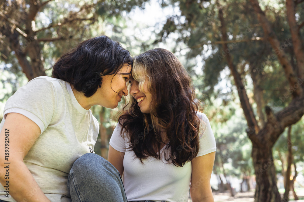 Mother and daughter enjoying a peaceful moment in the park during a sunny afternoon Mother and daughter enjoying a peaceful moment in the park during a sunny afternoon