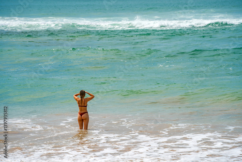 Obraz na płótnie Beautiful young girl enjoying the waves of the ocean w salonie
