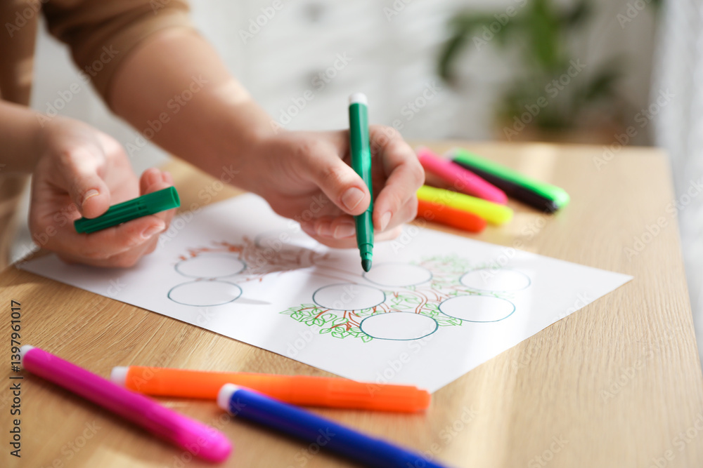 Woman drawing family tree at wooden table, closeup Woman drawing family tree at wooden table, closeup