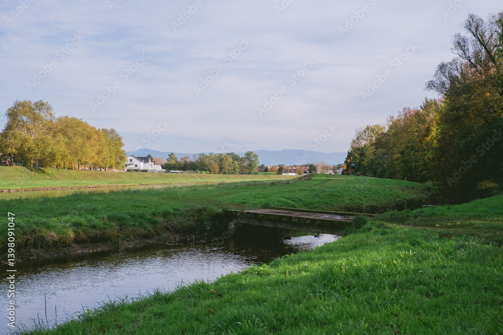 Fototapeta premium Grassy field with a small stream running through it