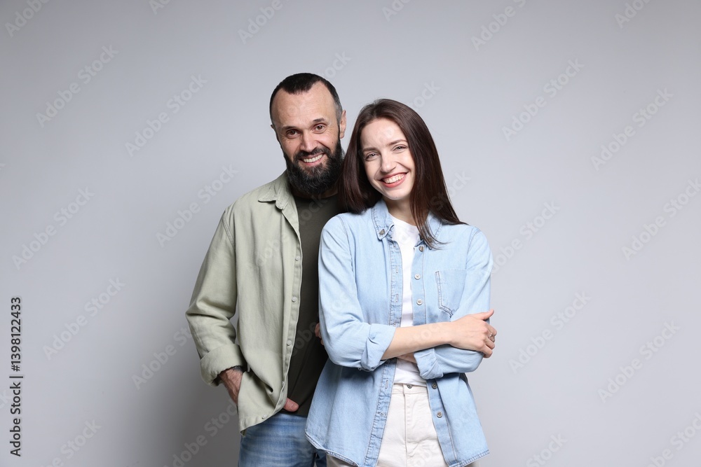 Portrait of happy daughter and father on light grey background Portrait of happy daughter and father on light grey background