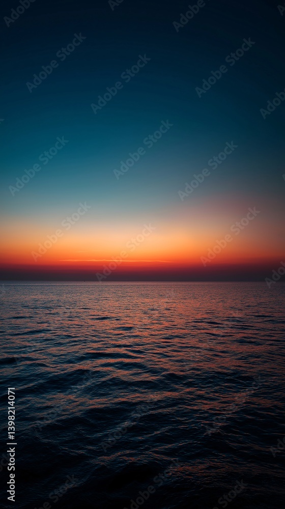 Obraz premium Ocean horizon at sunset with vibrant colors reflecting on the water.