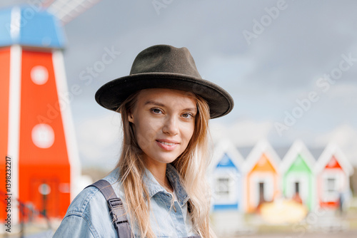 Obraz na płótnie Portrait handsome young farmer woman in uniform against background mill and of pen with cow. Concept business agriculture and livestock industry w salonie