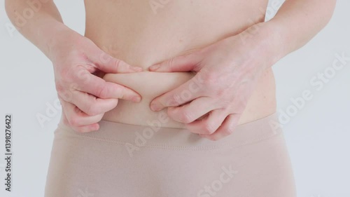 Wallpaper Mural Close up of female belly with loose skin Woman pinches skin to show body fat and signs of aging Loss of elasticity and soft tissue Torontodigital.ca