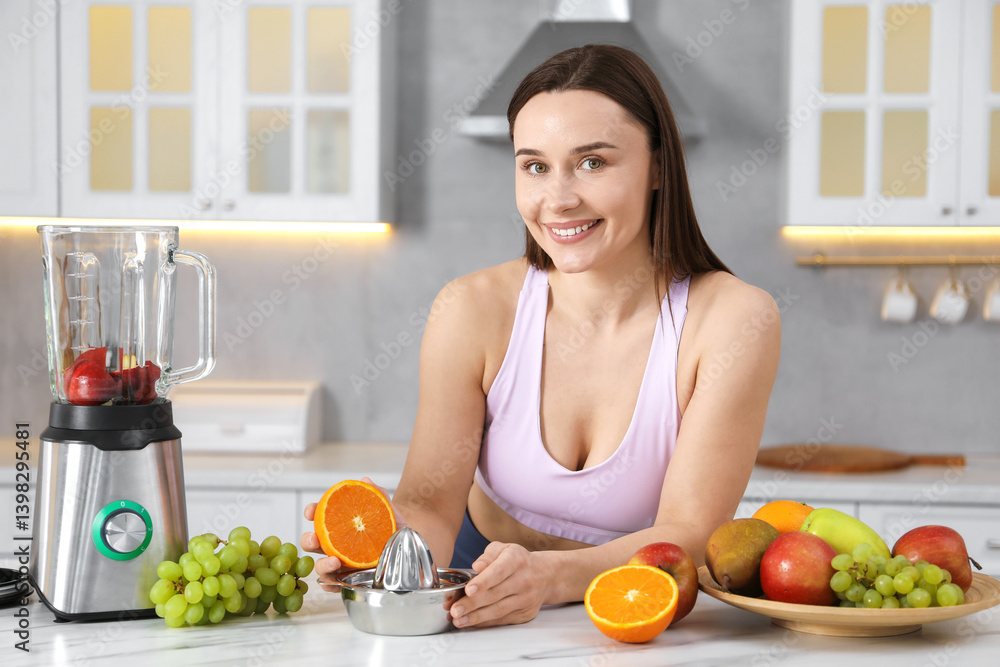 Woman in fitness clothes with orange and juicer making juice at white marble table indoors Woman in fitness clothes with orange and juicer making juice at white marble table indoors
