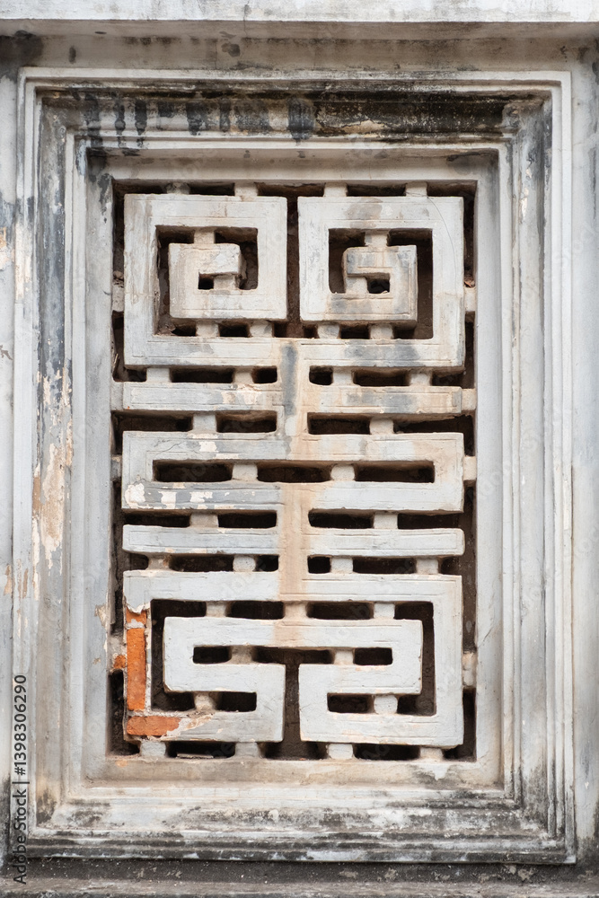Decorative stone window with geometric maze design at the Temple of Literature, Hanoi, Vietnam on December 29, 2019 Decorative stone window with geometric maze design at the Temple of Literature, Hanoi, Vietnam on December 29, 2019