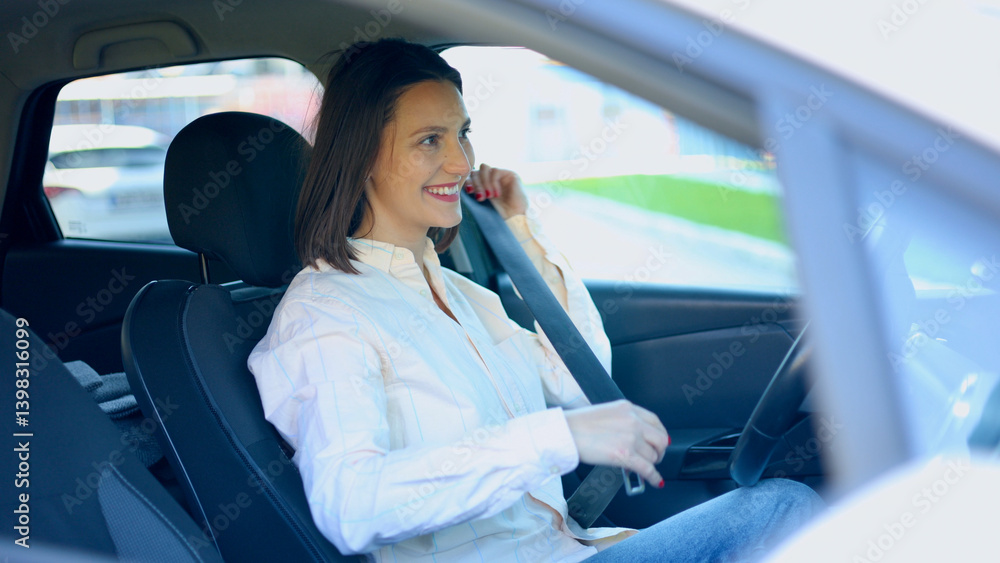 Smiling businesswoman fastening her seat belt while sitting in her car Smiling businesswoman fastening her seat belt while sitting in her car
