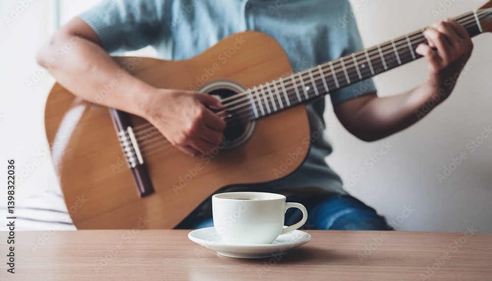 Fototapeta premium A cup of coffee and hands playing a guitar