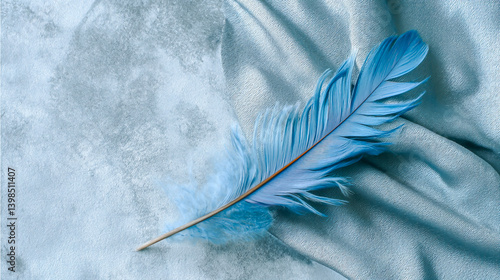 Blue aesthetic wallpaper featuring a single delicate blue feather resting on a soft, light blue velvet background, minimalistic and serene texture design.