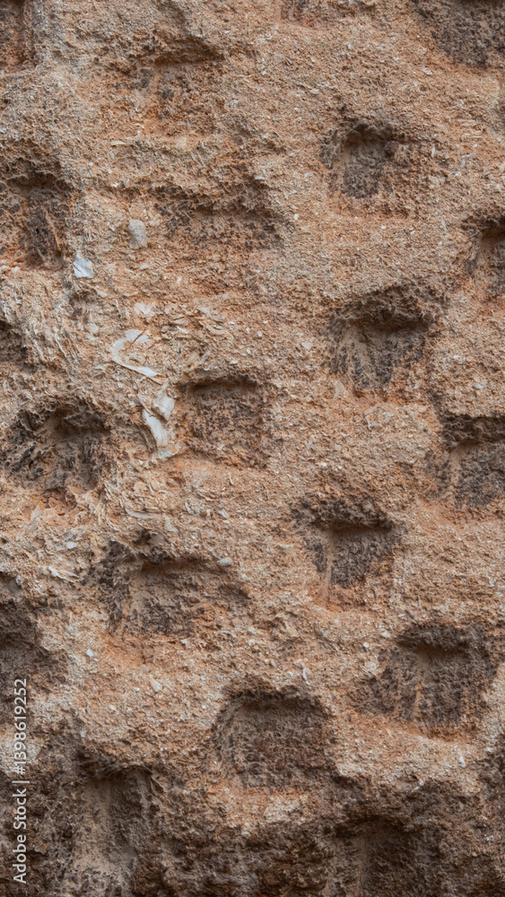 Texture of an old stone wall with small repetitive orifices Texture of an old stone wall with small repetitive orifices