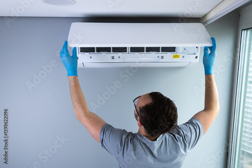 Technician Performing Maintenance on an Air Conditioning Unit While Wearing Protective Gloves in a Modern Indoor Setting