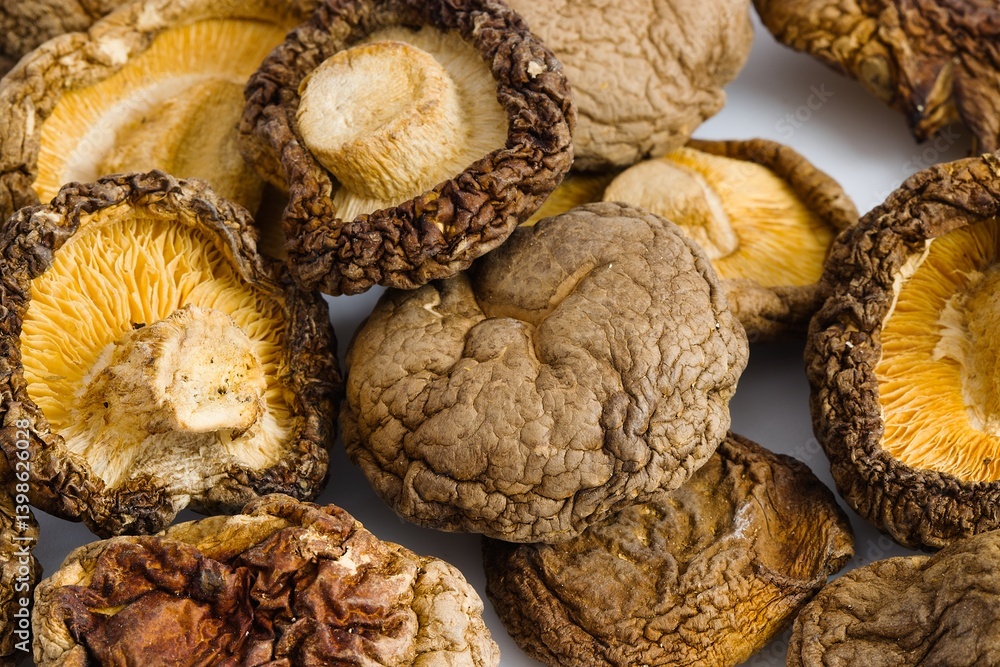 A sophisticated view of dried shiitake mushrooms on a white background, revealing their natural, rustic charm. A sophisticated view of dried shiitake mushrooms on a white background, revealing their natural, rustic charm.