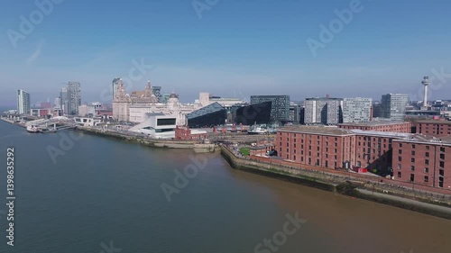 Wallpaper Mural Aerial view of Liverpool's waterfront featuring the Three Graces, Museum of Liverpool, Mann Island complex, and the River Mersey under a clear sky. Torontodigital.ca