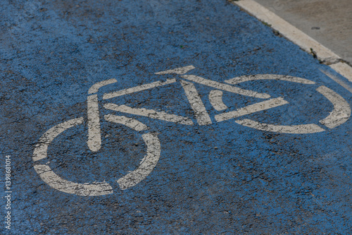 Bicycle lane marking on a vibrant blue pavement indicating safe space for cyclists in an urban setting photo
