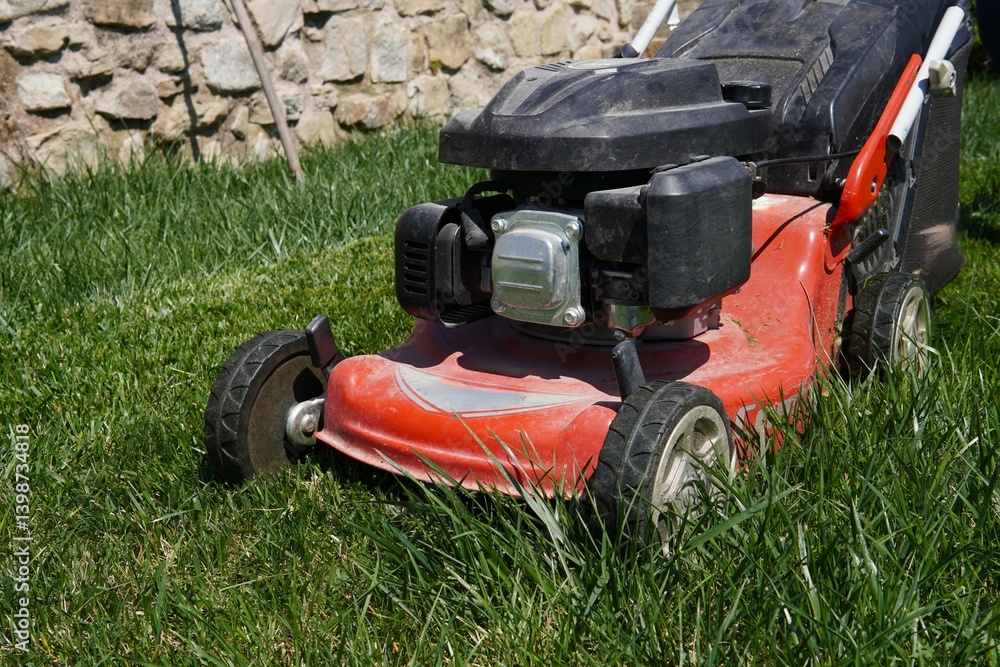 Obraz premium A lawn mower on a freshly mown lawn. The sharp contrast between the neatly trimmed surface and the untouched edges highlights the precise cutting ability of the lawn mower.