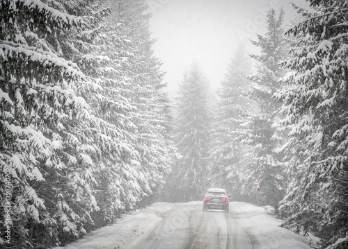 Obraz na płótnie Beautiful winter scene with icy slick road driving car . Alpine road covered with water and ice and snowy trees all around w salonie