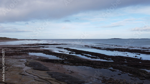 Coastal landscape with a view of rocks and the sea under a cloudy sky on a calm day
