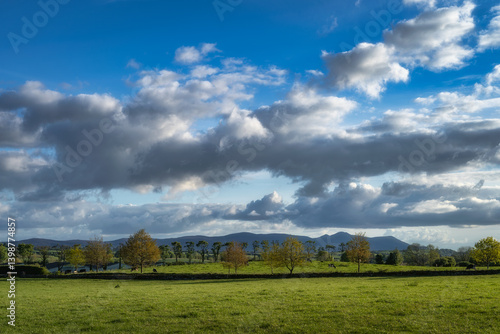 Obraz na płótnie This stunning landscape features green fields, majestic mountains, and dynamic clouds, making it a perfect spot for nature lovers to explore and appreciate, Tipperary, Ireland w salonie