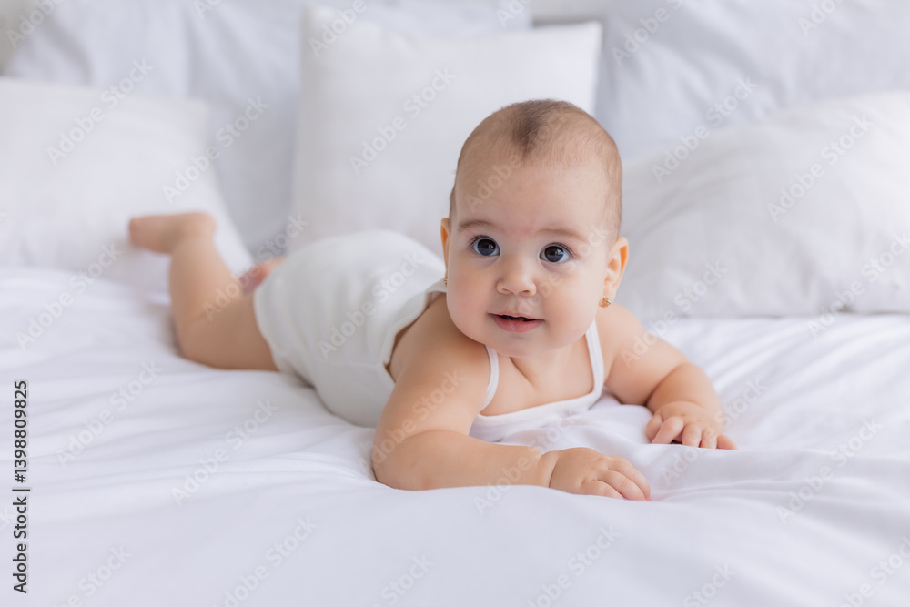 baby is lying on a bed with white linens baby is lying on a bed with white linens