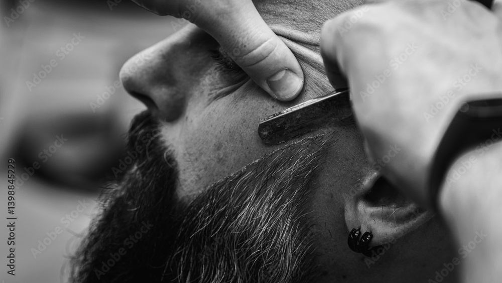 Black and white classic vintage photo, close-up, barber trimming beard with electric clipper, hair scissors in modern barbershop. Professional men's grooming and beard care services, selective focus
